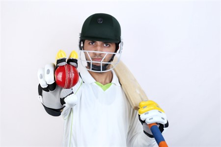 Cricket player batsman showing ball towards camera