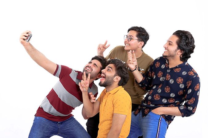 four friends taking a selfie with big smiles