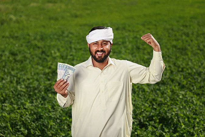 Man in traditional clothes looking happy while holding cash