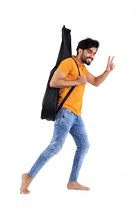 boy acting playful while wearing a guitar bag
