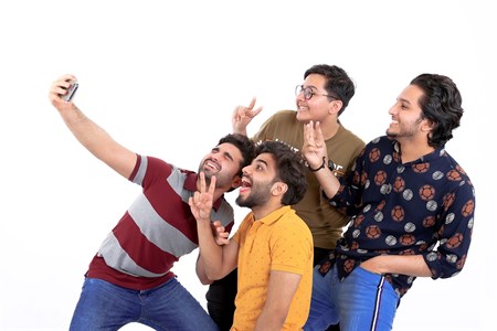four friends taking a selfie with big smiles