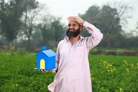 old man holding a house prop in one hand with looking for something expression
