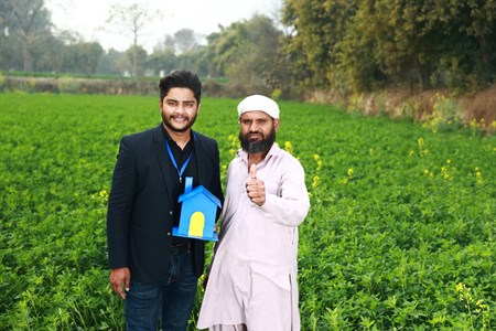 Farmer giving a thumbs up while standing with a banker
