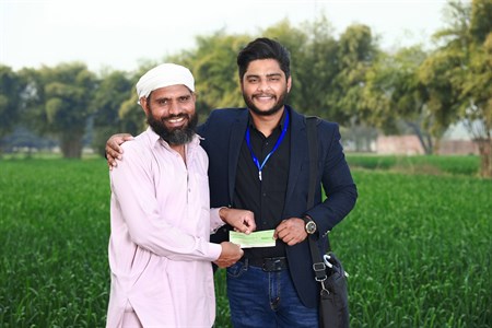 Banker giving cheque to the farmer
