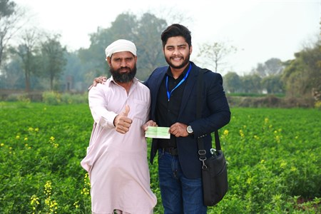 Banker giving cheque to the farmer who is giving thumbs up