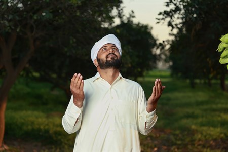 Man praying to God with both hand up in the air