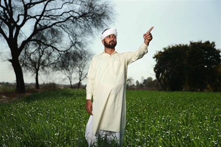 Man in traditional clothes pointing at something