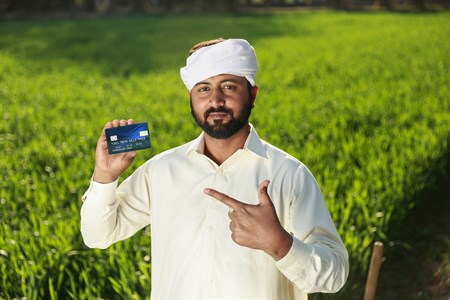 Man in traditional clothes pointing at debit/credit card