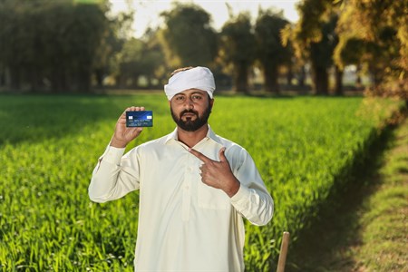 Man in traditional clothes pointing at debit/credit card