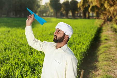 Man in traditional clothes holding a paper plane