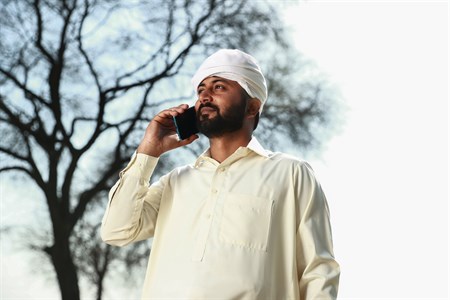 Man in traditional clothes calling on mobile phone