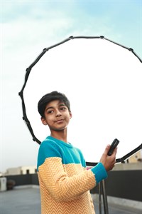 Kid with a big photography light source in background