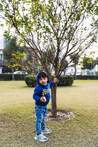 Playful kid with with tree in background