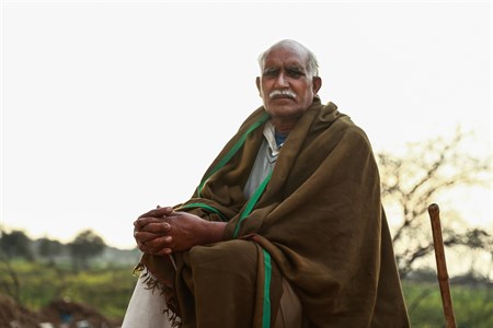 Old man wearing shawl with crossed hands