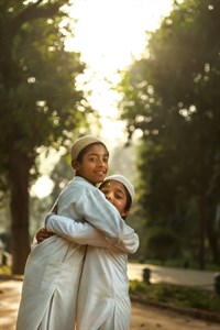 Kids wearing muslim cap hugging each other