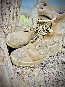 Soldier muddy shoes under tree